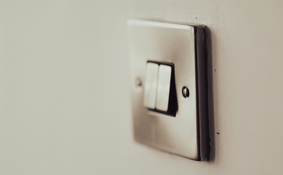 A silver light switch on a wall in a home with two switches